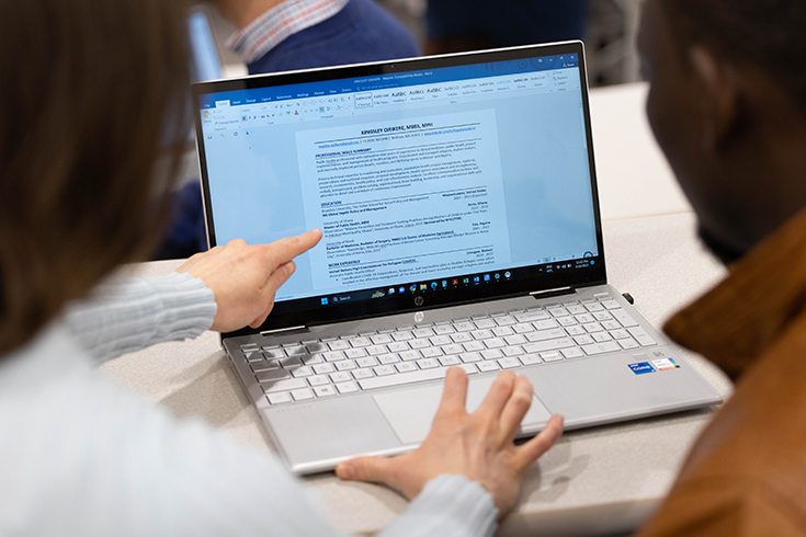 Graduate students talk to each other at the Heller School at Brandeis University on April 18, 2023. Photo/Dan Holmes