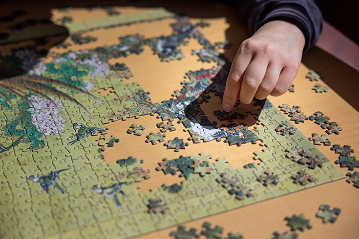 Elliot Busch, ’25, Puts in a puzzle piece at the puzzle station in Goldfarb Library on April 4, 2023. Photo/Gaelen Morse