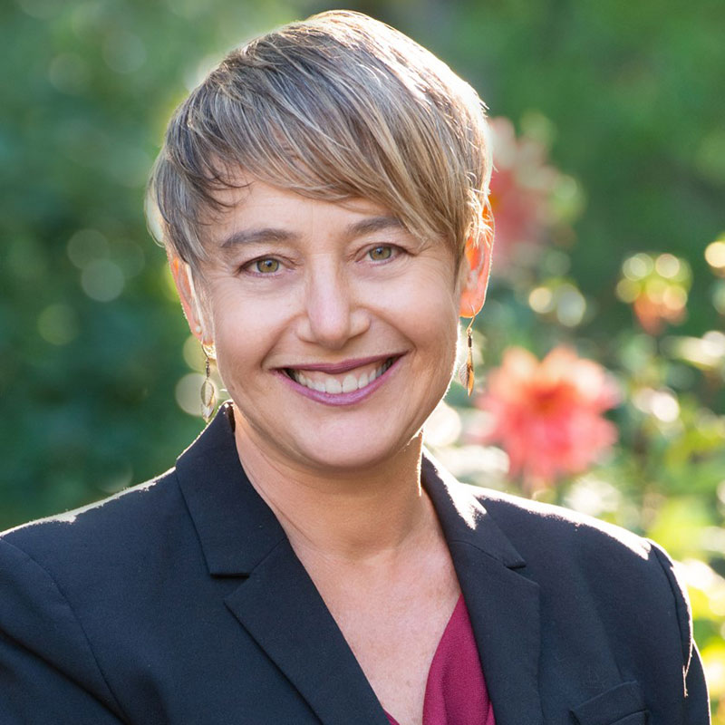 Idit Klein portrait photo with greenery behind her