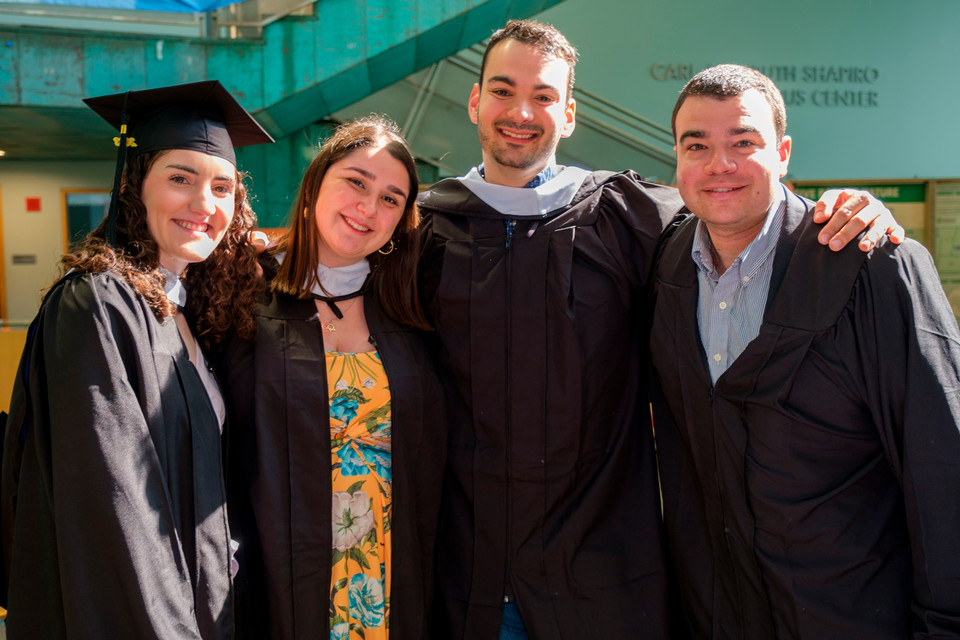 A group of students in caps and gowns pose at the 2023 graduation ceremony