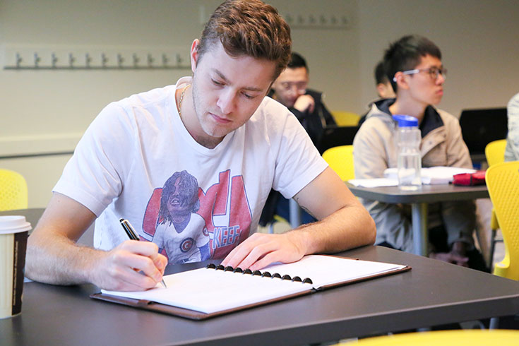 A student writing in a notebook during class