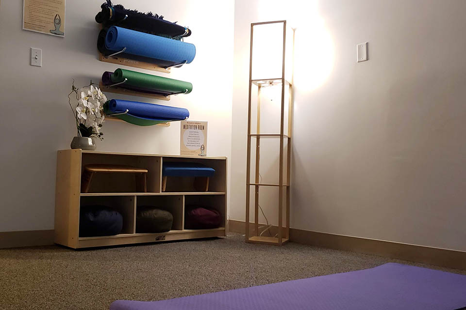 Room with yoga mats, prayer rugs, and cushions