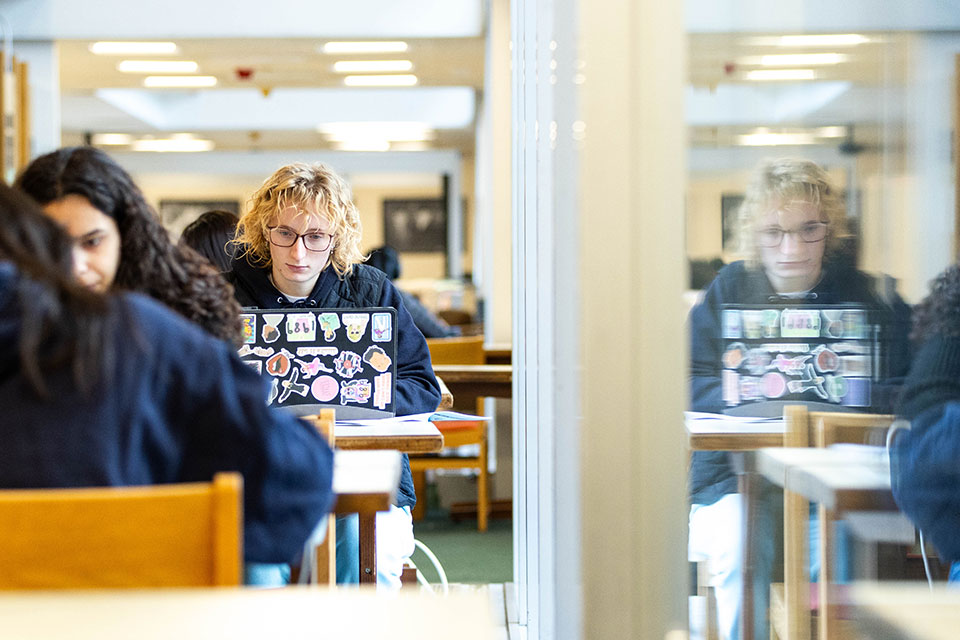 A student studies at a table in the library