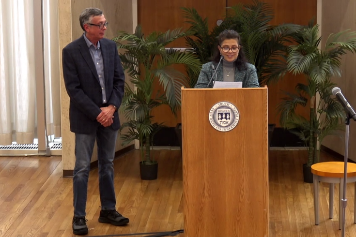 Bob Thomas standing beside a podium, waiting to receive the Rabb School's 2025 Outstanding Teaching Award