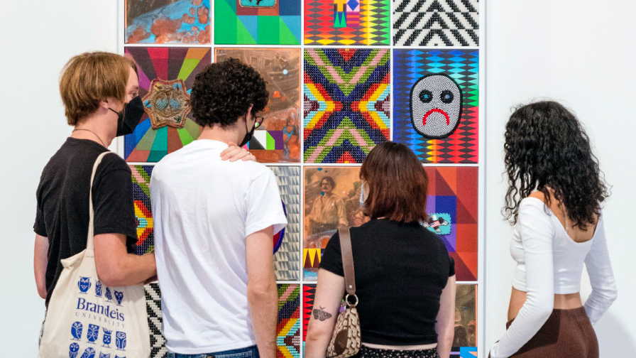 Brandeis students looking at a work of art by Jeffrey Gibson