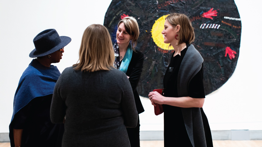 Four women talk in the Lois Foster Wing of the Rose Art Museum