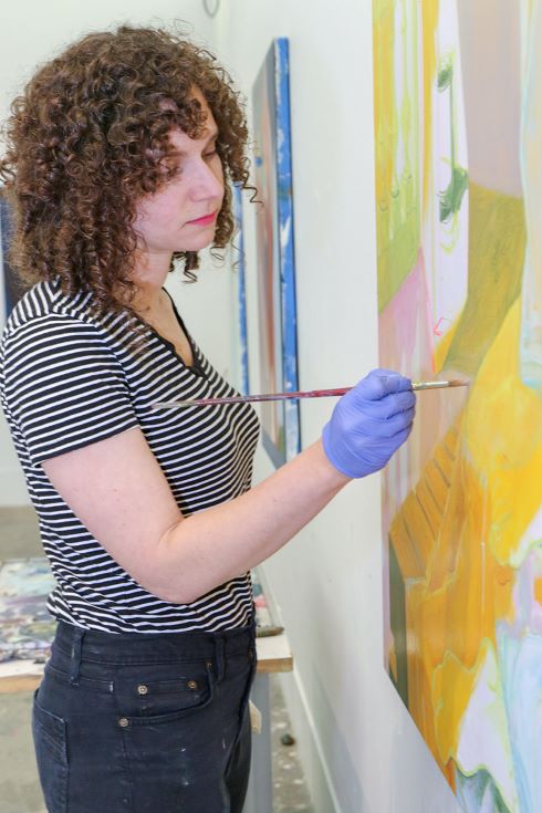A photograph of Anna Wehrwein painting in her studio by Joanna Eldredge Morrissey.